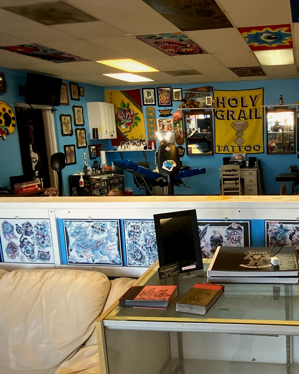 The reception area with the hand-painted Cash Only sign and Holy Grail Tattoo banner