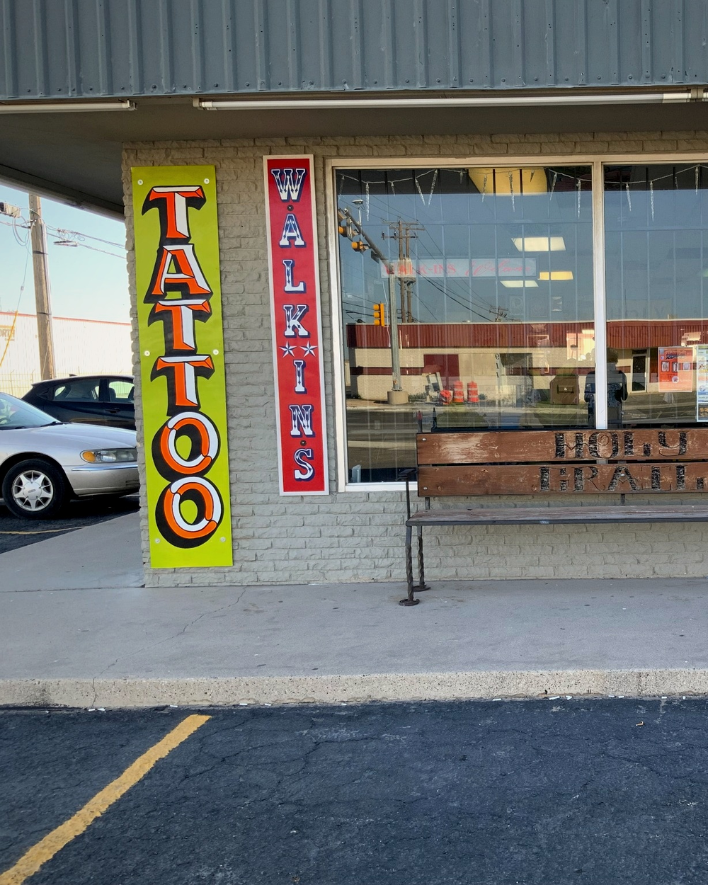The Holy Grail Tattoo storefront with its bench and Walk-Ins Welcome signs