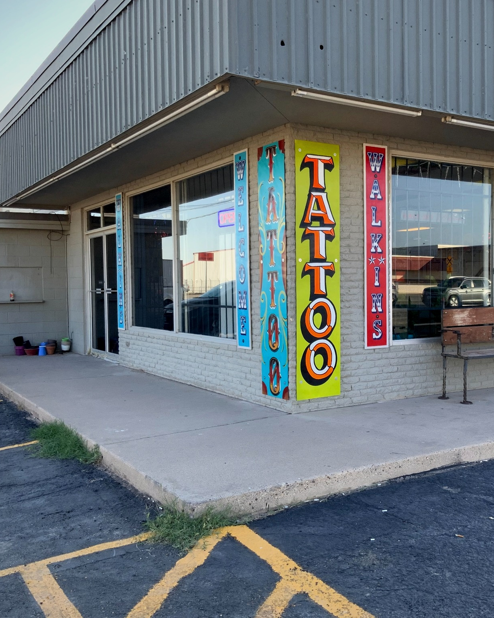The corner exterior of A Holy Grail Tattoo with its colorful painted signage