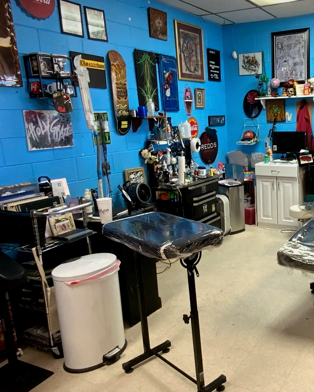 A private tattoo room with Sailor Betty's Tattoo Parlor artwork on the wall
